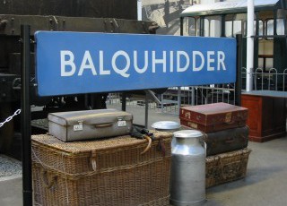 Scottish_Railway_Exhibition_trunks,_churns_and_station_sign.jpg